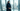 Woman in structured deep navy power abaya in modern Riyadh glass office tower with city skyline