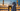 Woman in simple elegant white abaya before the illuminated Masjid al-Haram in Mecca at dusk