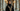 Woman in a black velvet abaya with pearl and gold embroidery in a palatial marble interior