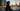 Woman in full black abaya with hijab standing at Dubai Marina at dusk with Burj Khalifa in background