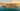 Aerial view of The Pearl-Qatar island at golden hour with the Doha skyline and West Bay towers reflected in the water